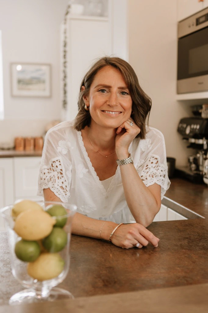 Sarah Bartlet leaning on her kitchen worktop, smiling warmly