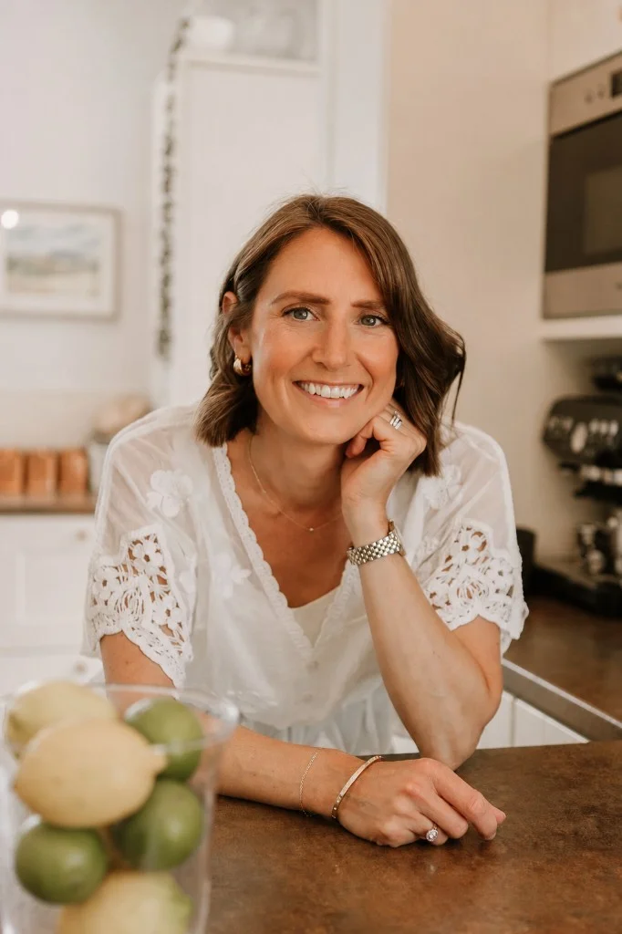 Sarah Bartlet leaning on her kitchen worktop, smiling warmly